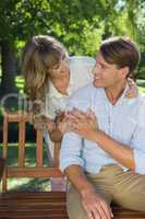 Affectionate couple relaxing on park bench together