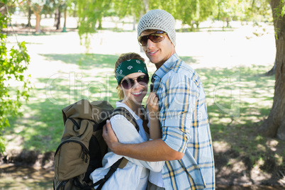 Active cute couple embracing each other on a hike smiling at cam
