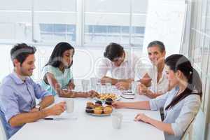 Work colleagues having hot beverages and muffins