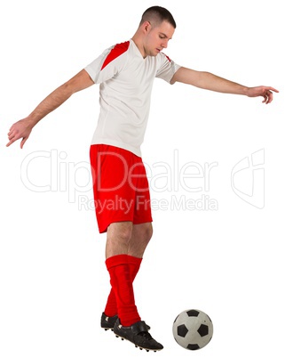 Fit football player playing with ball