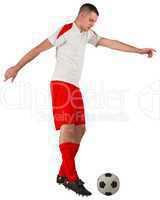 Fit football player playing with ball