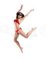 Fit girl in red bikini smiling and leaping