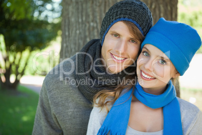 Cute couple smiling at camera in hats and scarves