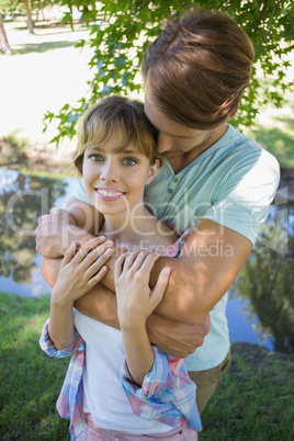 Affectionate young couple standing together in the park girl smi
