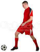 Fit football player playing with ball