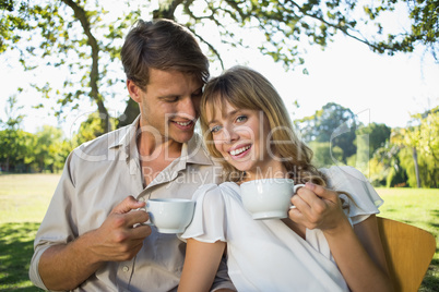 Smiling couple having tea outside in a cafe