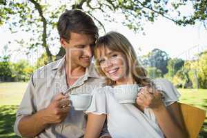 Smiling couple having tea outside in a cafe