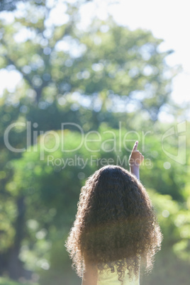 Young girl pointing to the sky in the park