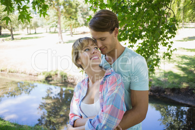 Affectionate young couple standing together in the park