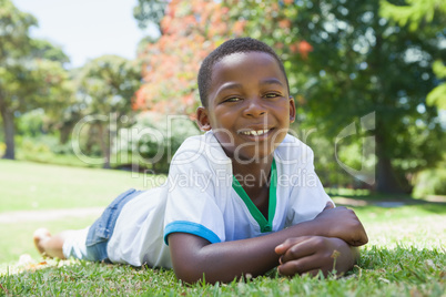 Little boy lying in the park smiling at camera