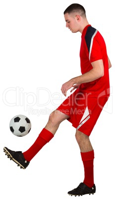 Fit football player playing with ball