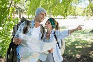 Active couple on a hike consulting the map