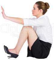 Businesswoman sitting on floor pushing