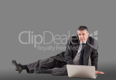 Concentrating businessman lying on floor using laptop Concentrating businessman lying on floor using laptop