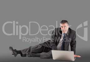 Concentrating businessman lying on floor using laptop