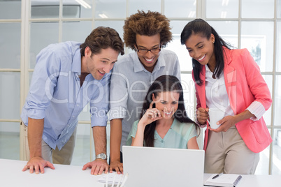 Coworkers interacting with laptop computer