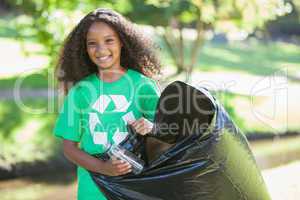 Young environmental activist smiling at the camera picking up tr
