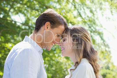 Attractive couple smiling at each other in the park
