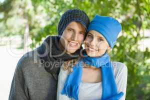 Cute couple smiling at camera in hats and scarves