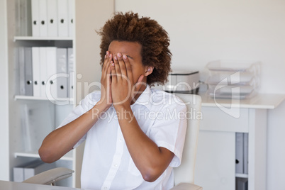 Casual stressed businessman covering face with hands