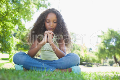 Young girl praying in the park