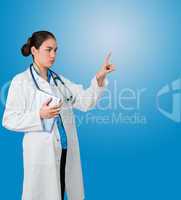 Serious doctor in lab coat holding tablet and pointing
