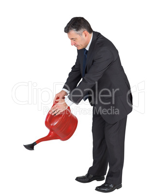 Mature businessman watering with red can