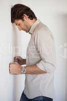 Casual worried businessman leaning on wall