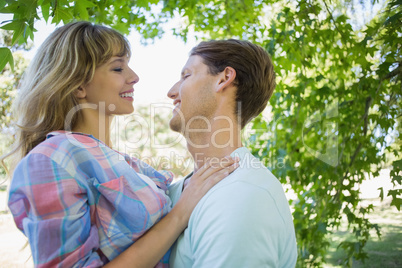 Cute couple smiling and hugging in the park