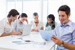 Attractive businessman using a tablet at work