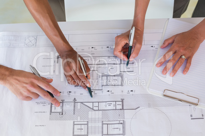 Team of architects going over blueprints Team of architects going over blueprints