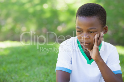 Cute upset boy thinking in the park