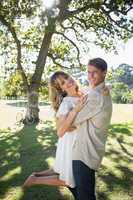 Smiling couple standing and embracing in park