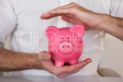 Casual businessman holding piggy bank