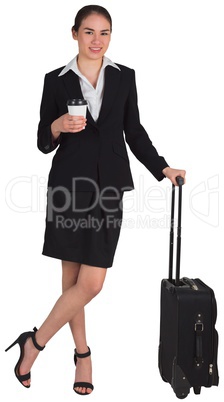 Businesswoman leaning on her suitcase holding coffee