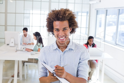 Casual businessman taking notes smiling at camera