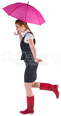 Pretty redhead businesswoman holding umbrella