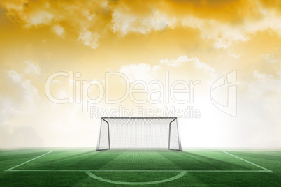 Football pitch and goal under yellow sky