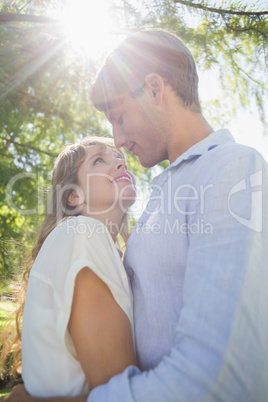 Cute couple hugging in the park and smiling at each other