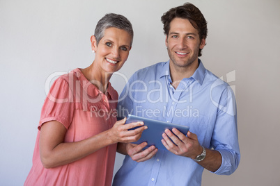 Casual smiling business team looking at tablet pc together