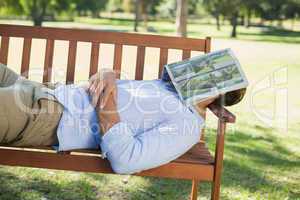 Man sleeping on park bench with newspaper over face
