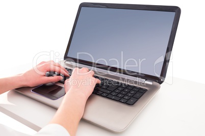 Hands typing on laptop