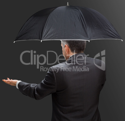 Businessman holding umbrella and reaching hand out