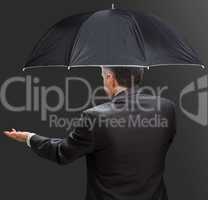 Businessman holding umbrella and reaching hand out