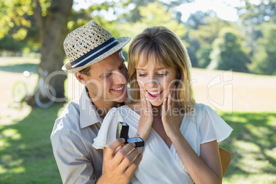 Man surprising his girlfriend with a proposal in the park