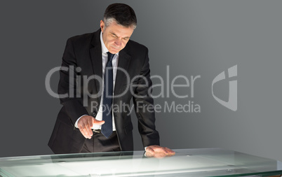 Concentrating businessman leaning on desk