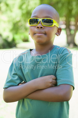 Cool little boy in sunglasses with arms crossed