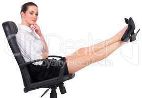 Businesswoman sitting on swivel chair with feet up