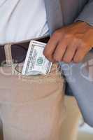 Dodgy businessman pocketing wad of dollars