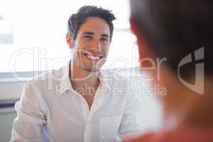 Casual business people talking at desk and smiling